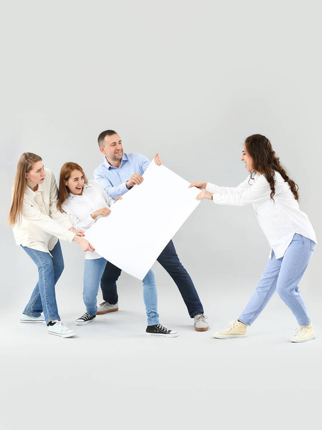 Group of people with blank poster on light background - Photo, Image