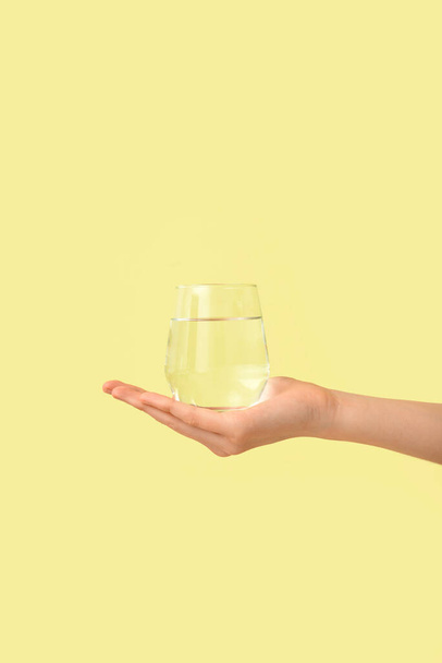 Female hand with glass of water on color background - Fotoğraf, Görsel