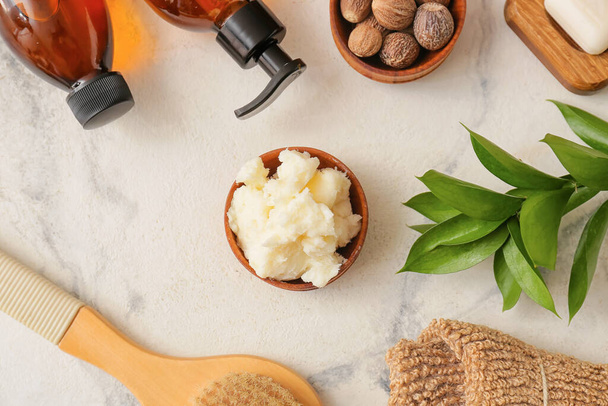 Bowl of shea butter and bath supplies on light background, closeup - Foto, immagini