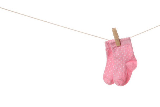 Chaussettes bébé suspendues à la corde sur fond blanc - Photo, image