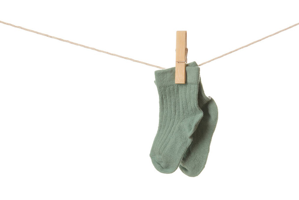 Baby socks hanging on rope against white background - Zdjęcie, obraz