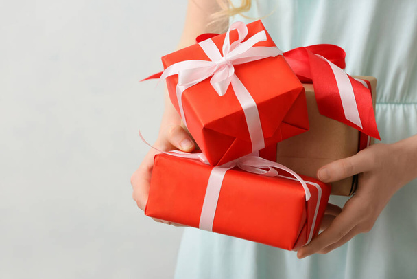 Woman with gifts on light background, closeup - Photo, Image