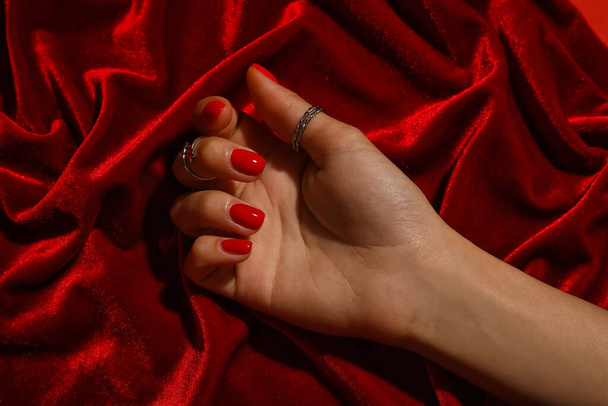 Női kéz gyönyörű manikűr színes szövet háttér - Fotó, kép