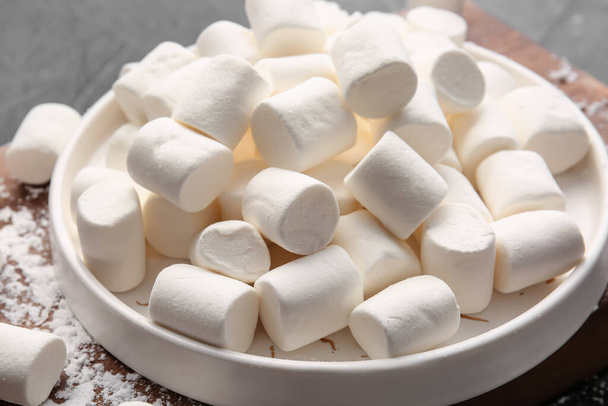 Plate with tasty marshmallows on dark background - Photo, Image