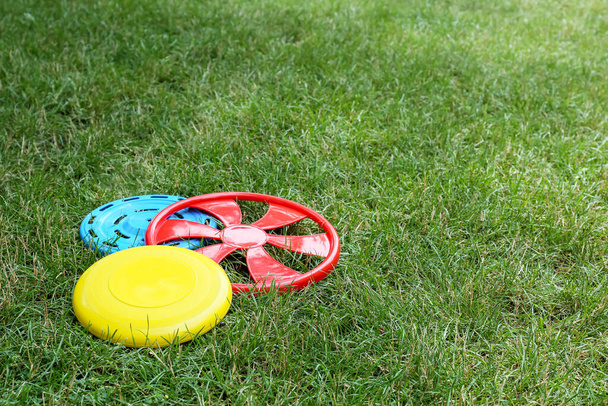 Diferentes discos de frisbee en la hierba al aire libre - Foto, imagen