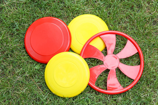 Diferentes discos de frisbee en la hierba al aire libre - Foto, imagen