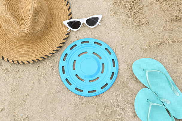 Σύνθεση με frisbee disk και αξεσουάρ παραλίας στην άμμο - Φωτογραφία, εικόνα