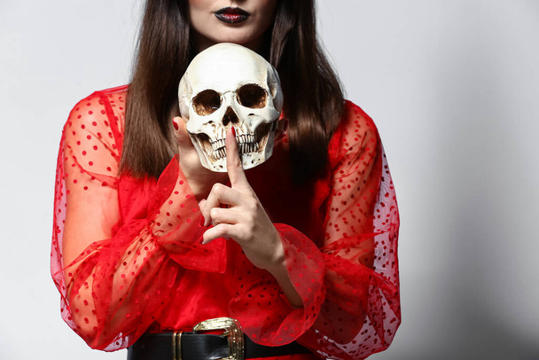 Jeune sorcière avec crâne sur fond clair - Photo, image