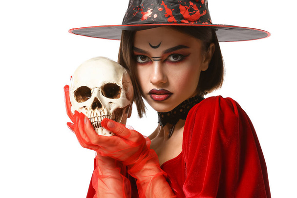 Молодая ведьма с черепом на белом фоне - Фото, изображение