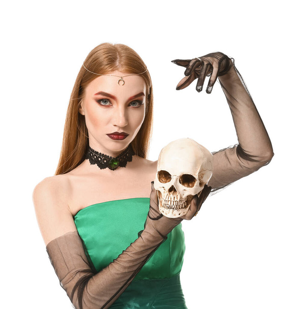 Joven bruja con cráneo sobre fondo blanco - Foto, imagen