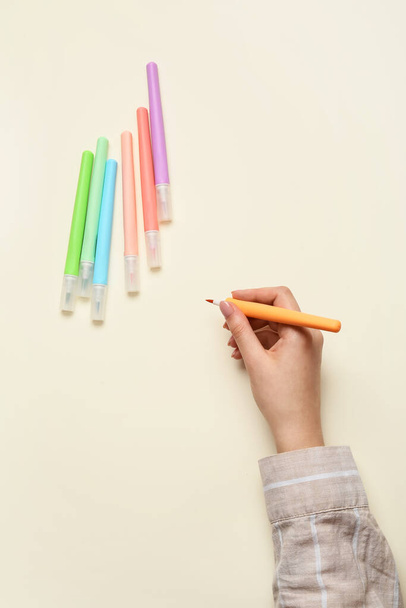 Mano femenina con marcadores de colores sobre fondo de color - Foto, Imagen