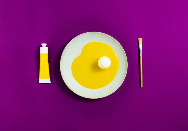 Artistic egg, with yellow egg white and white yolk on a white plate with purple background. Minimal concept. - Photo, Image