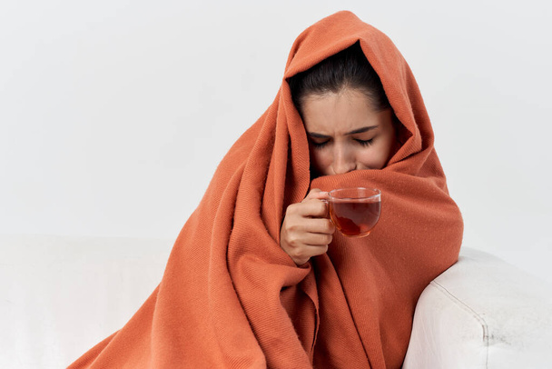 mujer malsana cubierta con una manta se sienta en el sofá tratado - Foto, imagen