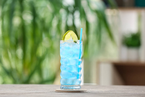 Glass of Blue Lagoon cocktail on table outdoors - Фото, зображення