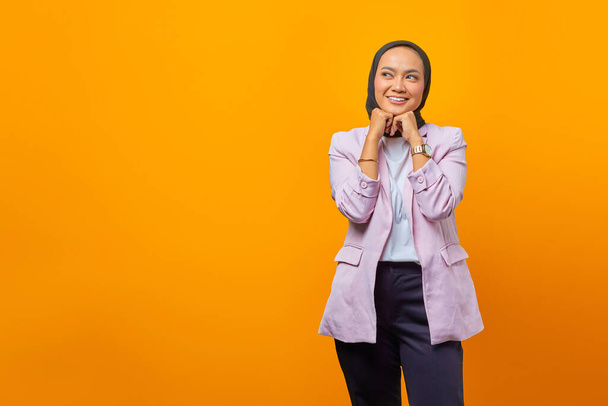 Ritratto di felice donna d'affari asiatica che guarda allegramente da parte con le braccia sollevate pieghevoli - Foto, immagini
