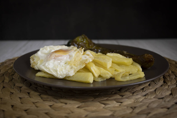 Картопля з смаженим яйцем і смаженим перцем, дуже затребуваною їжею на півдні Іспанії. Картопля не повинна бути заморожена, і вся домашня. Усі вони зроблені оливковою олією. Передній вид - Фото, зображення