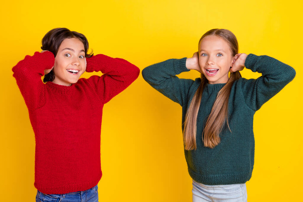 Portrait of attractive stunned cheerful couple closing ears having fun isolated over bright yellow color background - Foto, Bild