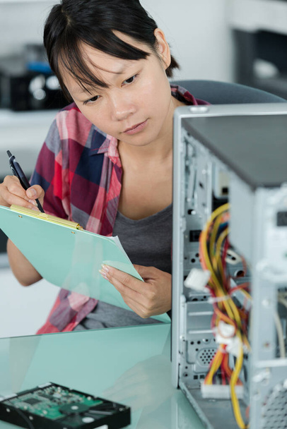 computer technician making notes on a clipboard - 写真・画像