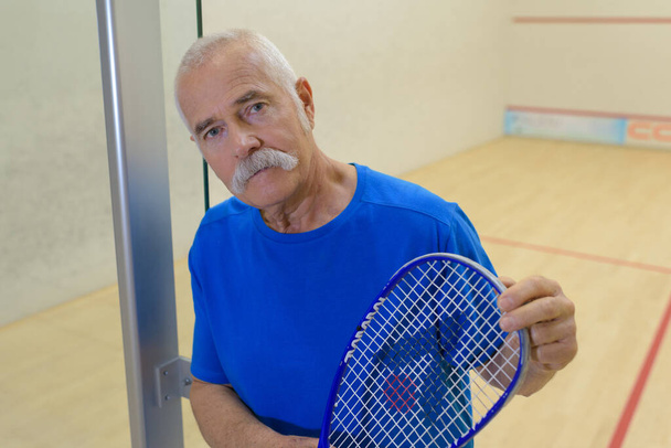 senior man on indoor court holding raquet - Φωτογραφία, εικόνα