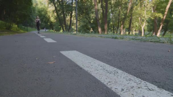 Slim erős motivált aktív nő kaukázusi hölgy női futó kocogás a parkban nyáron a friss levegőn szabadban élvezi a reggeli futás edzés sport edzés kardio sport gyakorlat - Felvétel, videó
