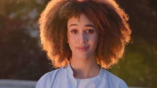 Female portrait outdoors young curly african american woman black mixed race smiling afro girl human model student looking at camera waving head yes positive answer agreement approval consent agree - Footage, Video