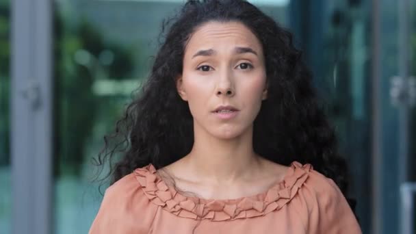 vrouw gezicht close-up portret buiten hispanic jong verlegen raadselachtig meisje brunette vrouw met krullend haar met nieuwsgierige uitdrukking knikt hoofd ja antwoorden positief akkoord goedkeuring steun eens - Video