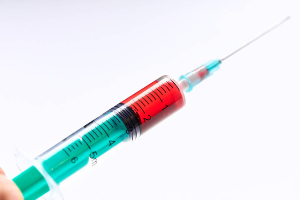 Closeup of hand holding vaccine in vial with syringe - Photo, Image