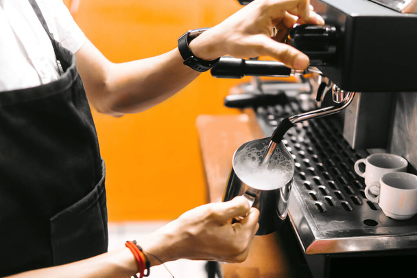 A closeup of a person making coffee with a coffee machine - Fotó, kép