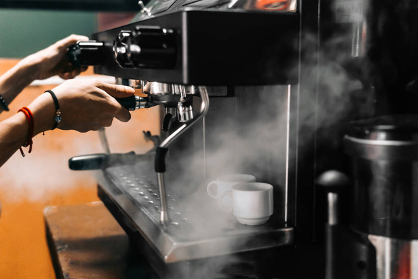 A closeup of a person making coffee with a coffee machine - Foto, imagen