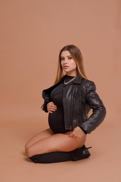 έγκυος γυναίκα στο στούντιο σε μπεζ φόντο - Φωτογραφία, εικόνα