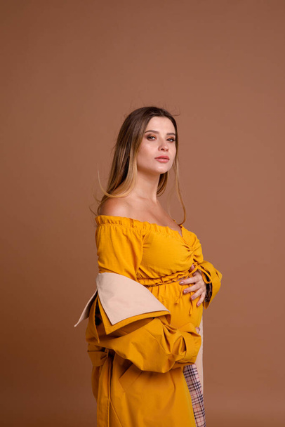 pregnant woman in studio on beige background - Photo, Image