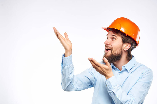 emotionele man oranje helm op het hoofd Studio hand gebaar - Foto, afbeelding