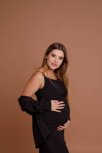 pregnant woman in studio on beige background - Fotoğraf, Görsel