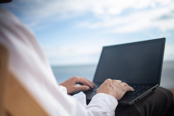 Jeune homme avec tablette pendant les vacances à la plage tropicale. Freelance travaillant sur ordinateur portable couché sur une chaise longue. - Photo, image