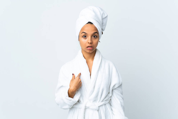 Fiatal nő fürdőköpenyben elszigetelt fehér háttér mutatva magát - Fotó, kép