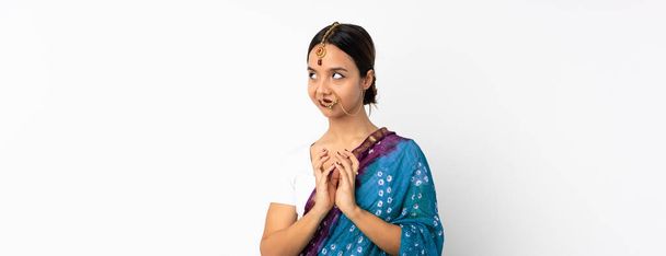 Молода індійська жінка ізольована на білому тлі, розбираючи щось
 - Фото, зображення