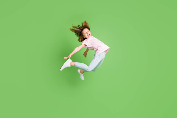 Foto lateral do perfil de tamanho completo da menina feliz sorriso positivo saltar para cima voar ar isolado sobre fundo de cor verde - Foto, Imagem