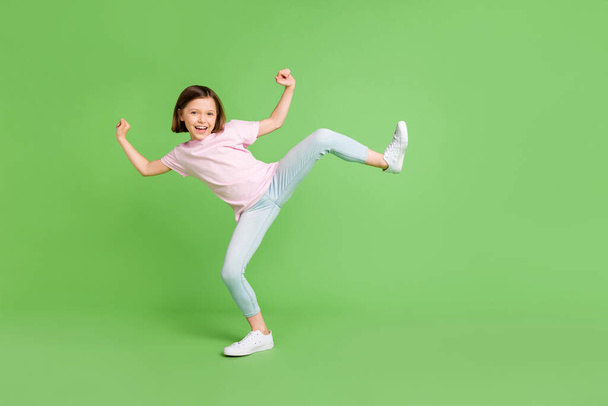 Full size profile side photo of young girl happy positive smile playful fooling dance isolated over green color background - Photo, image