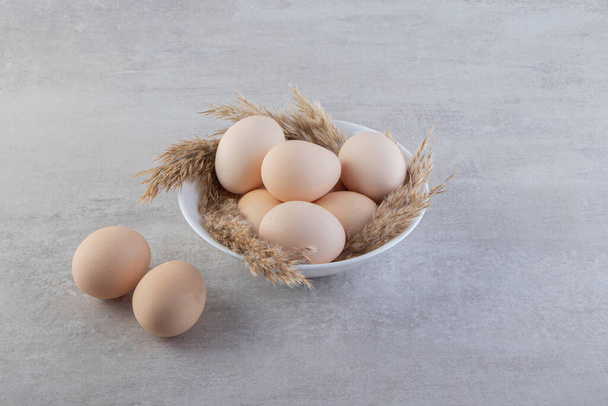 Ακατέργαστα φρέσκα λευκά αυγά κοτόπουλου τοποθετημένα σε πέτρινο φόντο. Υψηλής ποιότητας φωτογραφία - Φωτογραφία, εικόνα