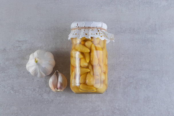 Glass jar full of pickled peppers   - Fotó, kép