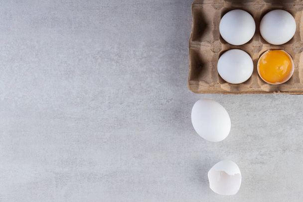 Сирі свіжі білі курячі яйця розміщені на кам'яному фоні. Високоякісна фотографія
 - Фото, зображення