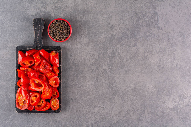 Pickled tomatoes with pepper corns placed on a stone background. High quality photo - Fotoğraf, Görsel