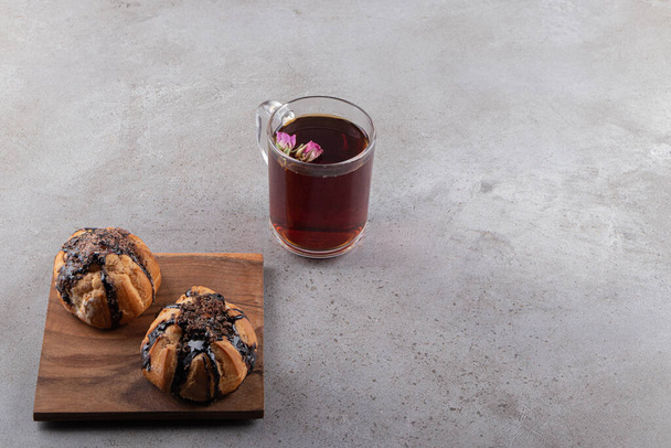 Cookies with chocolate coating and a glass cup of black tea . High quality photo - Φωτογραφία, εικόνα
