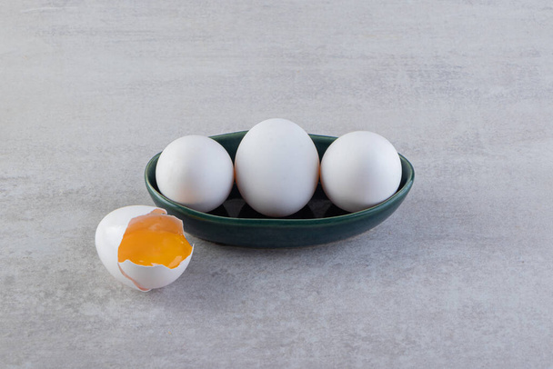 Raw fresh chicken eggs placed on a stone background. High quality photo - Foto, imagen