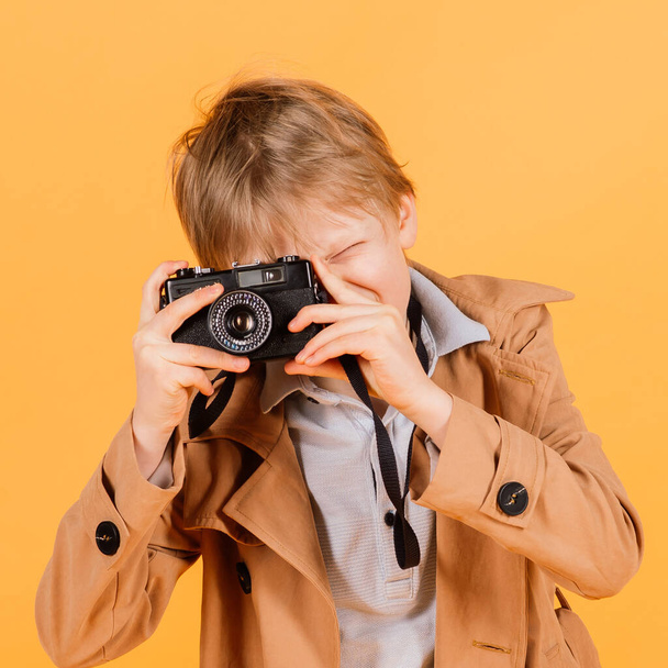 Bambino ragazzo rosso testa fotografo con fotocamera retrò in uno studio - Foto, immagini