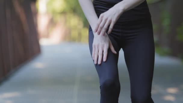 Крупный план женские ноги в черных леггинсах неузнаваемо стройные активные активные женщины бег бег бег утром бег тренировки перестает чувствовать боль в колене страдает от повреждения суставов травмы - Кадры, видео