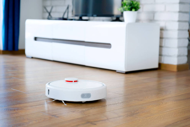 Robotic vacuum cleaner cleaning the room. Smart home concept - Foto, Imagem