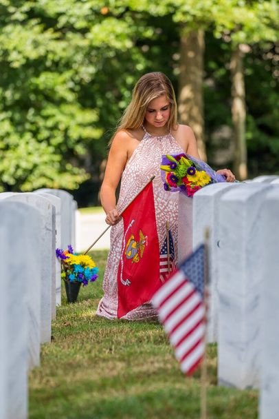 Eine junge Braut zeigt ihre Trauer am Grab eines Familienangehörigen auf einem Soldatenfriedhof - Foto, Bild