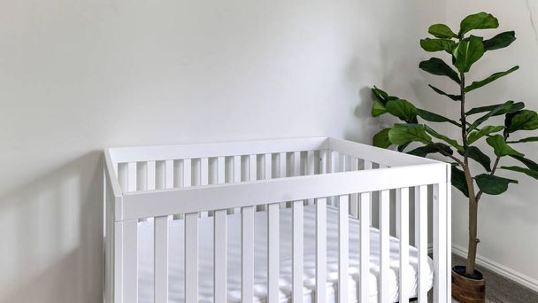 Pano Fehér gyerekszoba fehér gyermekágy, kamera monitor és szürke szőnyeg padló - Fotó, kép