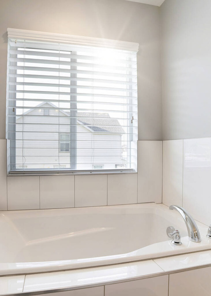 Κατακόρυφη μπανιέρα και παράθυρα με θέα το σπίτι των γειτόνων σε ένα μικρό χώρο μπάνιο - Φωτογραφία, εικόνα